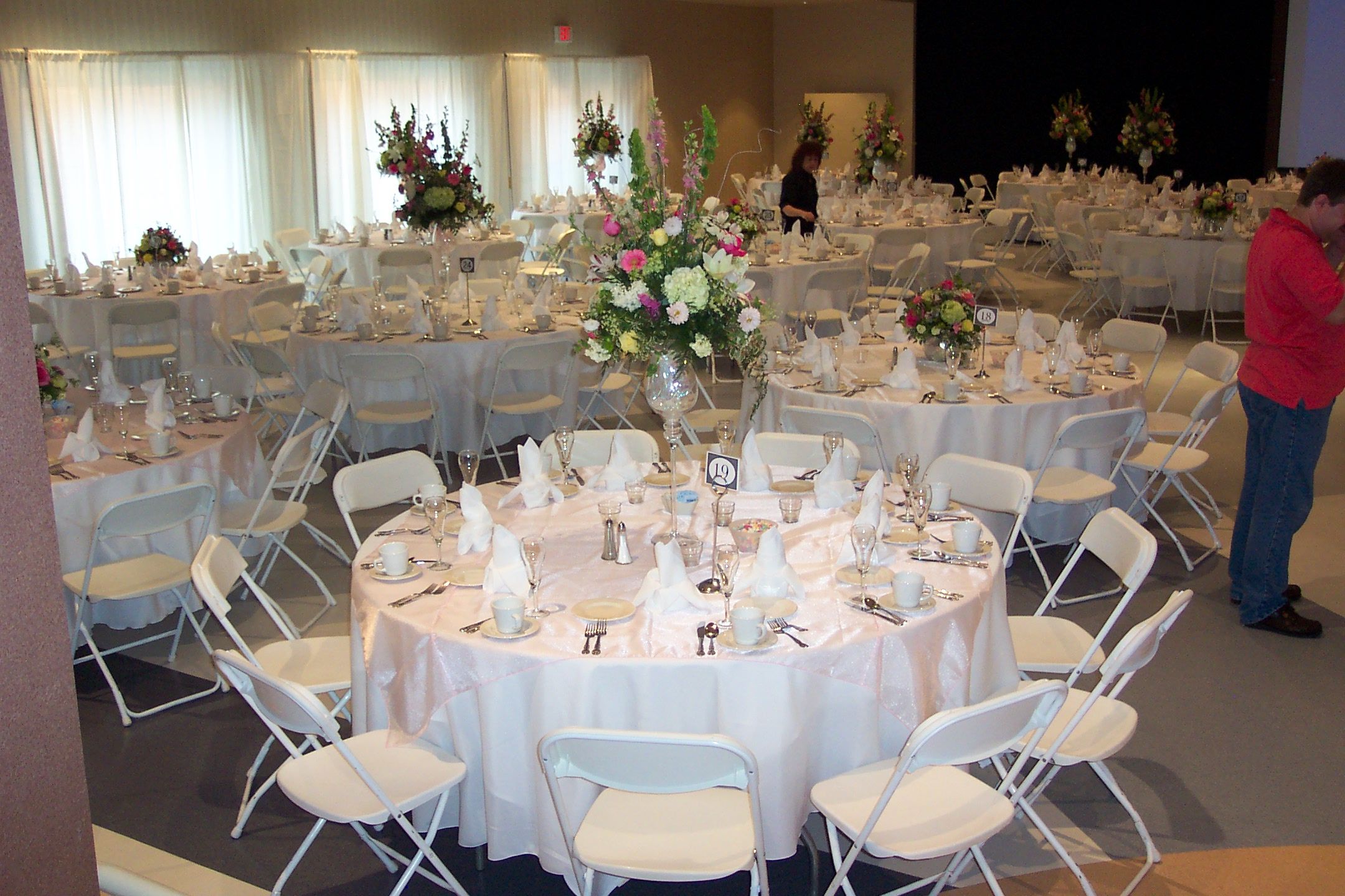 tables set for wedding reception with linens and floral arrangements